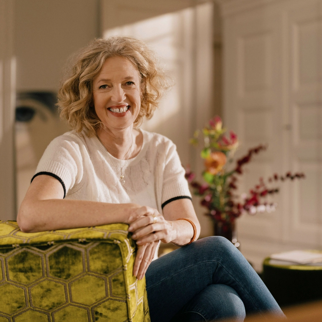 Christiane Schirmaier - freie Art-Direktorin aus Freiburg - lachend im Sessel sitzend
