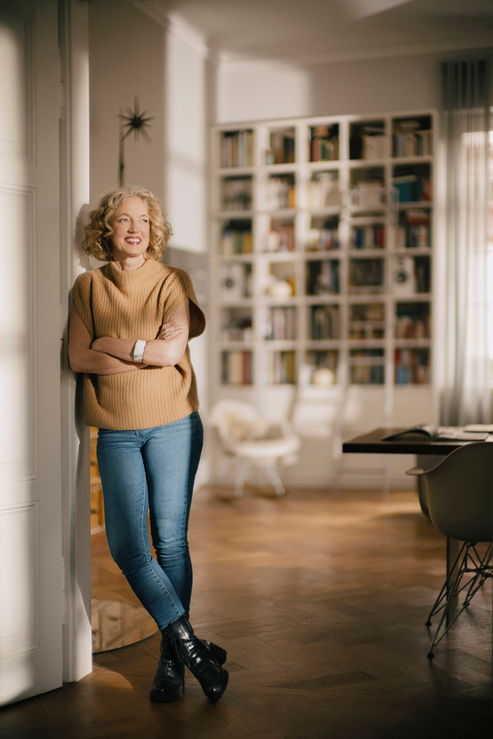 Designerin Christiane Schirmaier-steht angelehnt und guckt in den Raum